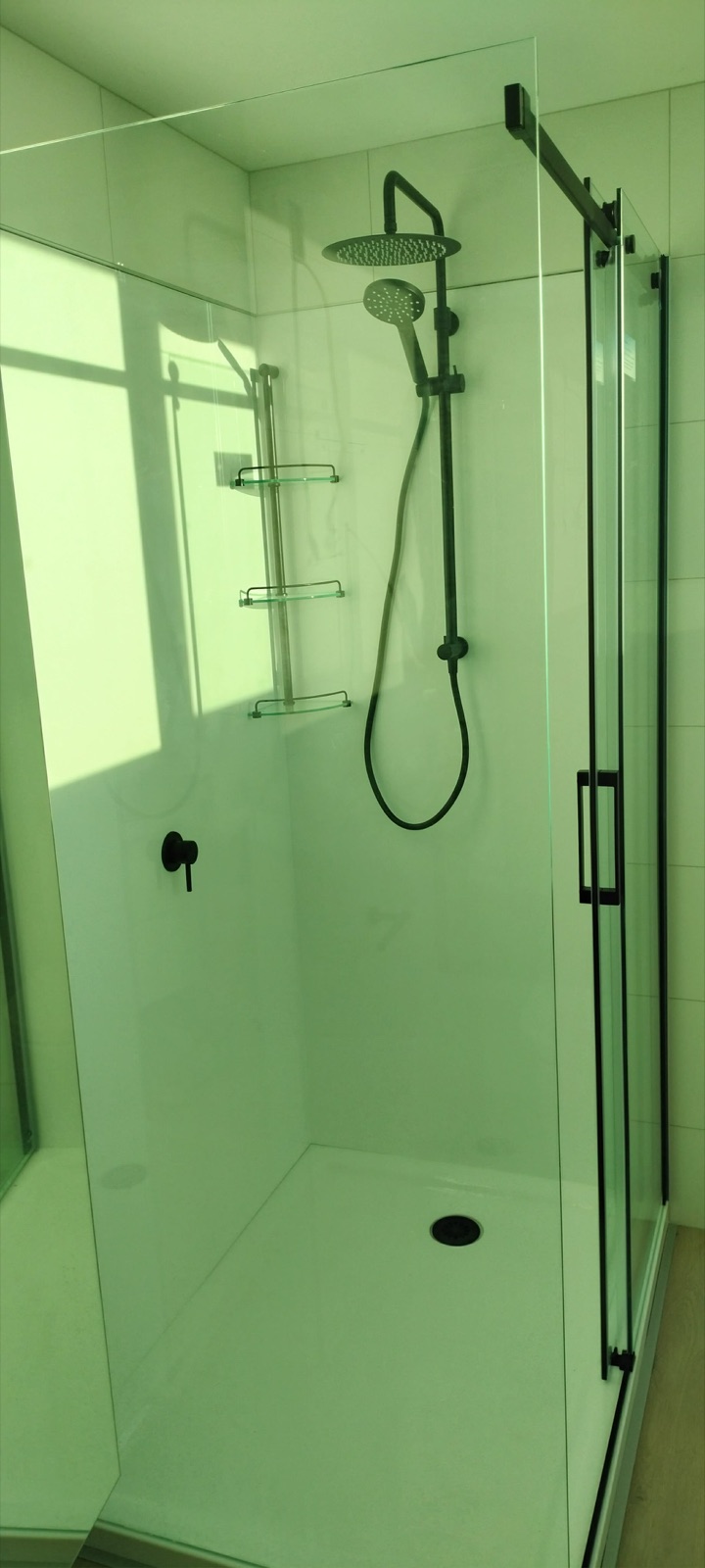 Tiled walk-in shower, black tapware